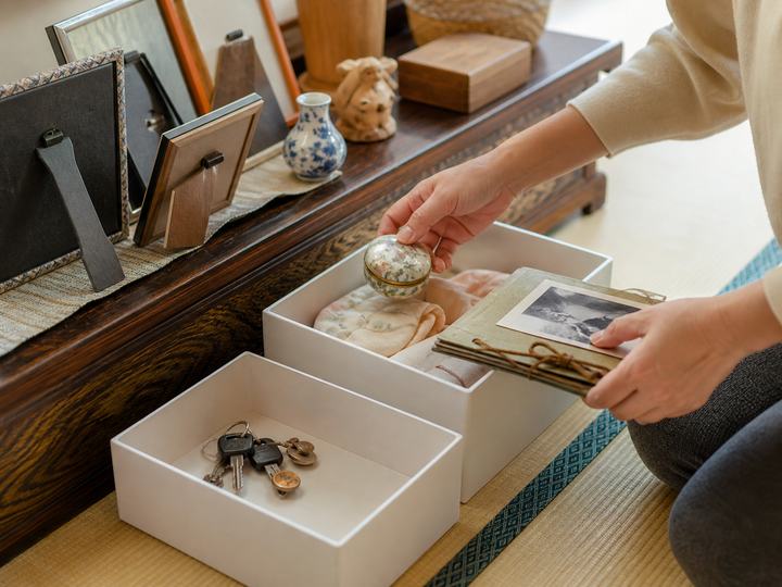 実家で写真や思い出の品を箱に分ける場面