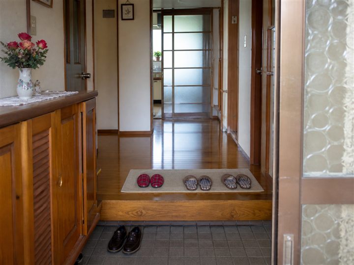 木の靴箱とすりガラス戸がある昔ながらの実家の玄関イメージ